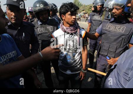 Dhaka, Bangladesh. 26th November 2013. Policemen arrest a supporter of the main opposition Bangladesh Nationalist Party (BNP) as BNP supporters demonstrate in the streets during the 48-hour country wide blockade of road, rail and water transport, in Dhaka, Bangladesh, 26 November 2013. Stock Photo