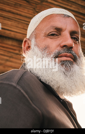 Portrait of Arab man wearing a mussar and sporting a long gray beard outside Deira Fish Market. Dubai, UAE. Stock Photo
