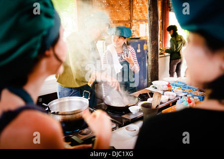 A tutor instructing a pupil at the Tum Tum Cheng Cooking School, Luang Prabang, Laos. Stock Photo