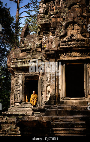 A monk sitting resting in the ruins at Thommanon, Siem Reap, Cambodia. Stock Photo