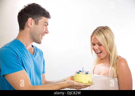 Man giving woman a cake on her birthday Stock Photo