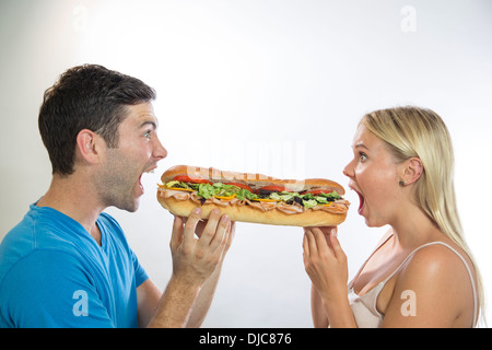 Man and woman eating sandwich Stock Photo