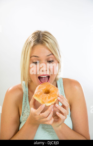 Young woman eating a donut Stock Photo