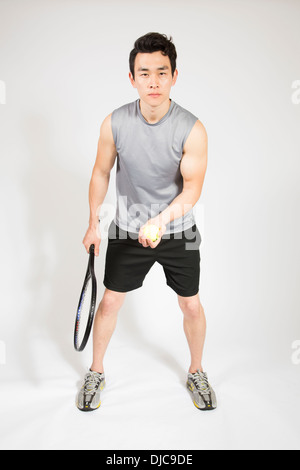 Athletic male holding tennis raquet and ball Stock Photo