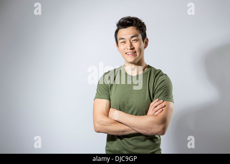 Athletic young male standing with arms folded Stock Photo