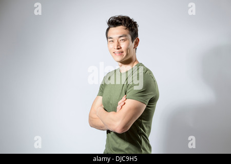 Athletic young male standing with arms folded Stock Photo
