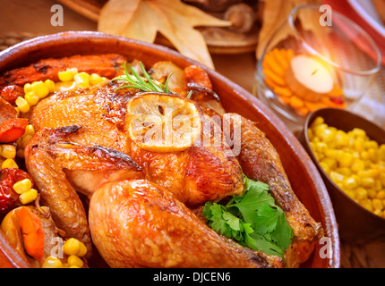 Closeup on tasty roasted chicken with vegetables on the table, traditional food of Thanksgiving day, autumnal holiday concept Stock Photo