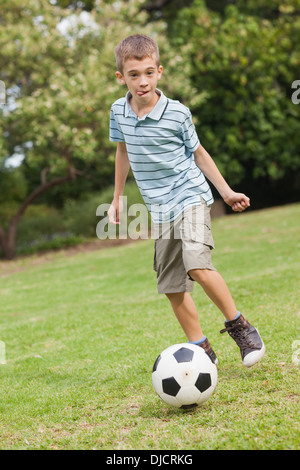 Son posing while playing football Stock Photo
