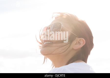 Woman in sunglasses looking up at sky Stock Photo