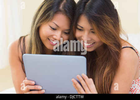 Two pretty sisters using a tablet Stock Photo