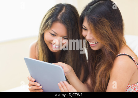 Two smiling brunette sisters using a digital tablet Stock Photo