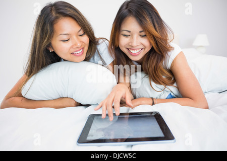 Two smiling brunette sisters using a tablet Stock Photo