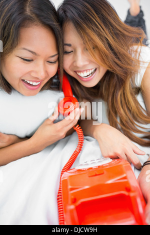 Two young sisters having fun with a telephone Stock Photo