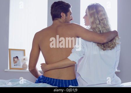 Attractive young couple sitting on their bed Stock Photo