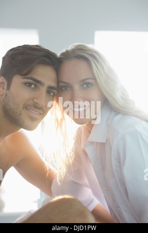Attractive young couple posing sitting on their bed Stock Photo