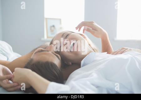Content laughing couple lying on their bed Stock Photo