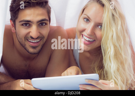 Sweet couple lying under a blanket Stock Photo