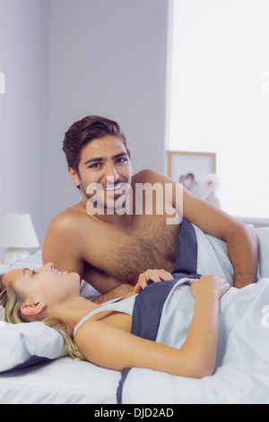 Young man lying in the bed with his girlfriend Stock Photo