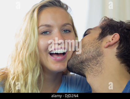 Laughing cute woman being kissed on her cheek Stock Photo