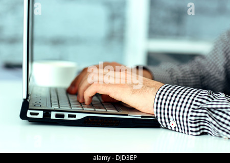 Closeup image of a male hands typing on laptop keyboard Stock Photo