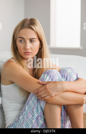 upset woman hugging knees and sitting on bed at home Stock Photo - Alamy
