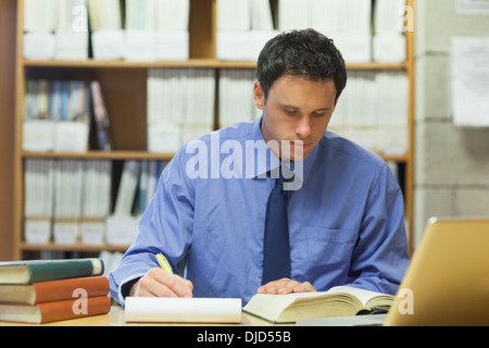 Calm librarian taking notes of a book Stock Photo