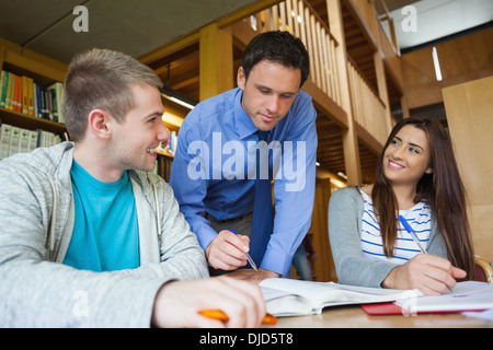 Attractive lecturer explaining something to students Stock Photo