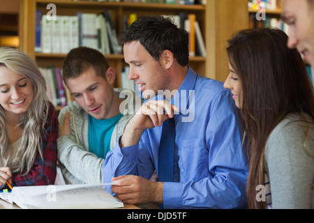 Lecturer explaining something to smiling group of students Stock Photo