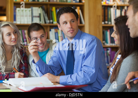 Handsome lecturer explaining something to group of students Stock Photo