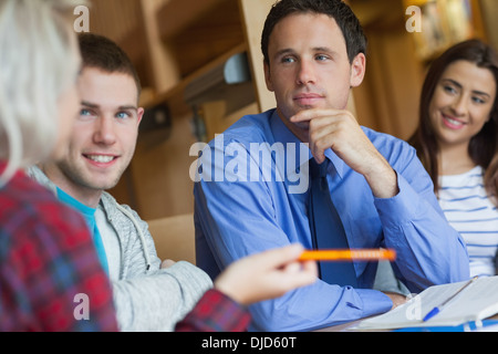 Focused lecturer explaining something to group of students Stock Photo