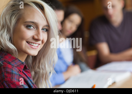 Blonde smiling student studying with other students Stock Photo