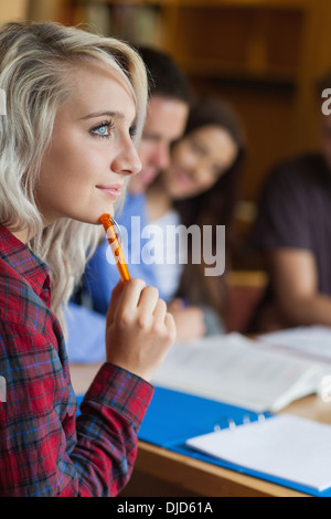 Blonde thoughtful student studying with other students Stock Photo