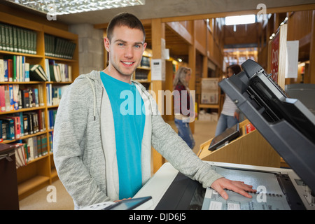 Happy good looking student using photocopier Stock Photo