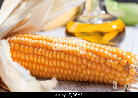 Corn cob with corn oil in background Stock Photo