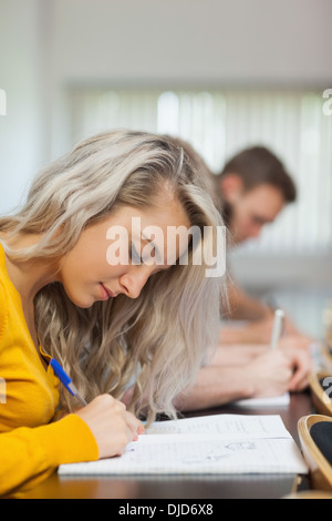 Blonde focused student taking notes Stock Photo