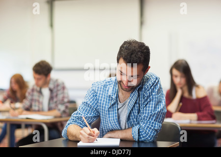 Focused student taking notes in class Stock Photo