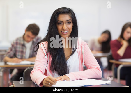 Happy indian student taking notes in class Stock Photo