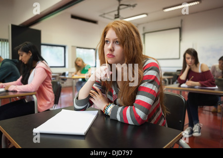 Bored female student listening in class Stock Photo