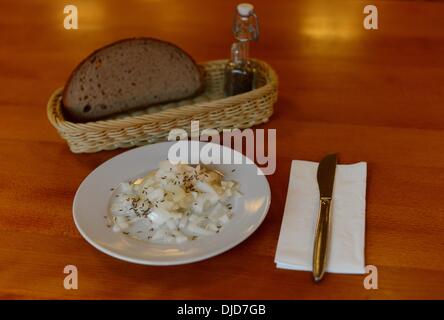 A plate of sour milk cheese with onions (Handkäse) and vinegar are on a plate in a typical Frankfurt cider tavern on 21.11.2013. Photo: Frank May Stock Photo