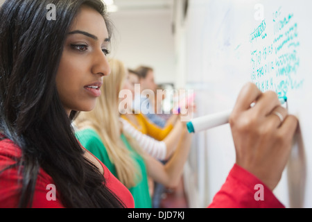 Students writing on the whiteboard in class Stock Photo