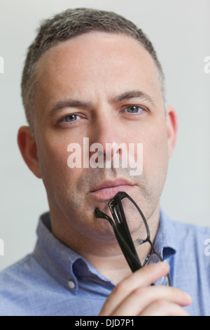 Serious teacher holding her glasses Stock Photo - Alamy