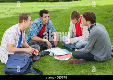 Smiling students studying together outside on campus Stock Photo