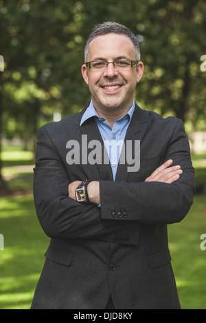 Happy professor looking at camera with arms crossed on campus Stock Photo