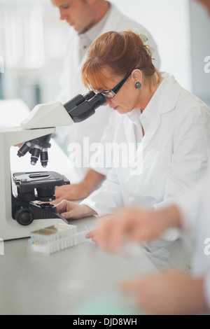 Female scientist looking through a microscope Stock Photo