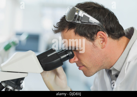 Handsome young scientist looking through a microscope Stock Photo