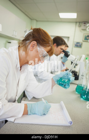 Profile view of three scientists working in a laboratory Stock Photo