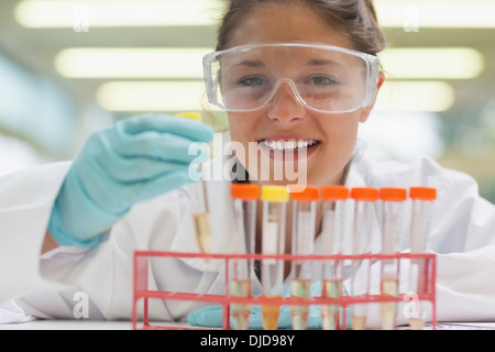 Cheerful student placing test tube in rack Stock Photo