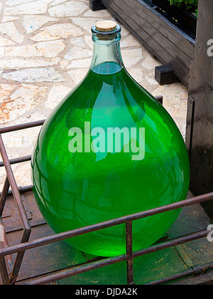 large antique glass bottle with light green liquid as medicine and