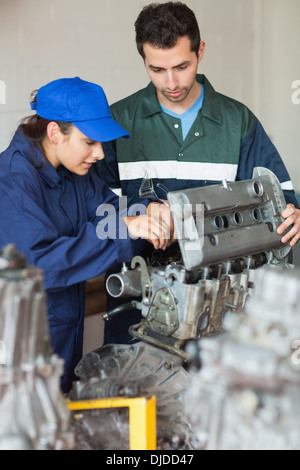 Trainee repairing engine with instructor Stock Photo