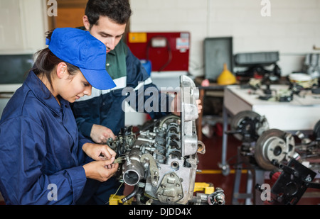 Focused trainee and instructor checking engine Stock Photo